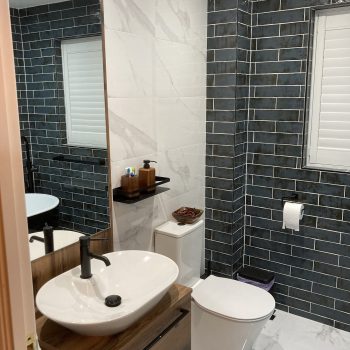 close up image of sink with grey tiles