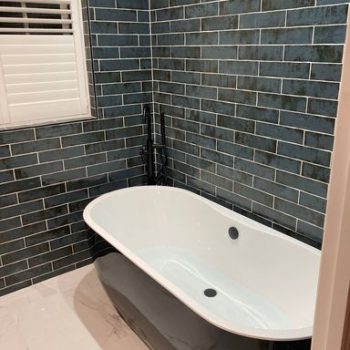 close up image of bath with dark grey tiles